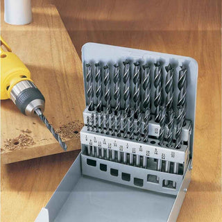 Set of brad point drill bits in a holder with a drill on a wooden surface