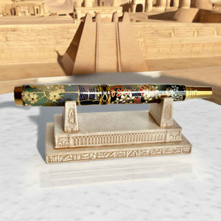 Pharaoh's Pen Stand displaying a handcrafted fountain pen with an Ancient Egyptian temple backdrop.