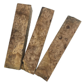 Three pieces of burl wood on a light blue background