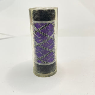 Cylindrical pen blank with purple interior and black exterior on a white background