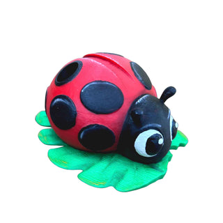 Side profile of the colorful ladybug pen holder with textured leaf base.