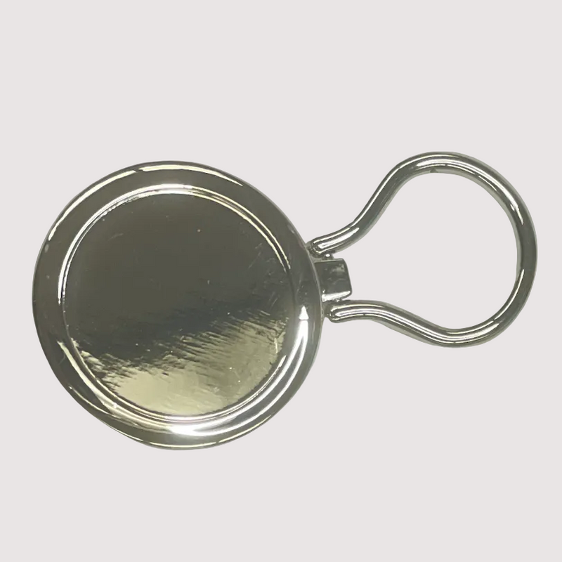 Metallic keychain with round reflective surface on a light gray background